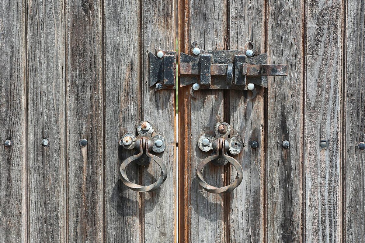 Cerrojo y aldabas en una puerta de madera